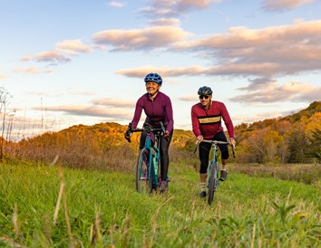 78e8bf6c-e6b0-4a47-a481-653befaec704-281-woman-and-man-ride-bikes-together-on-fall-day-in-pepin-county
